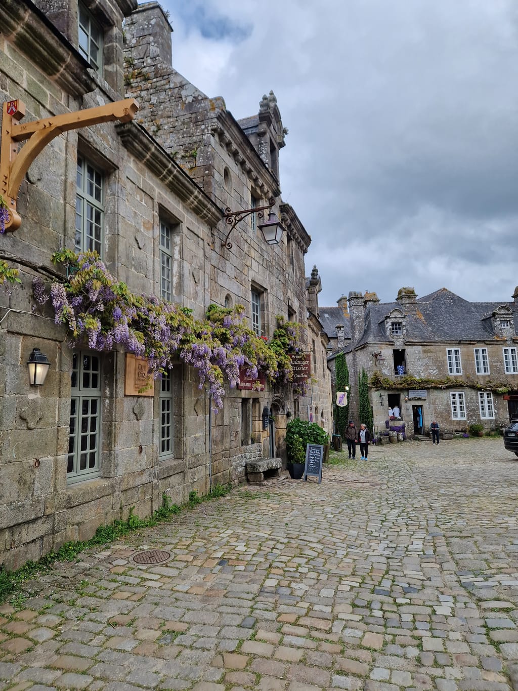 Le facciate in pietra di Locronan con il glicine in fiore