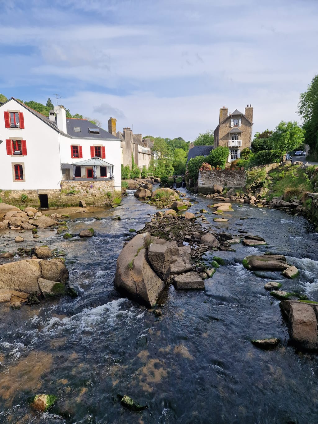 Il fiume Aven che scorre tra i massi di granito e le case del borgo